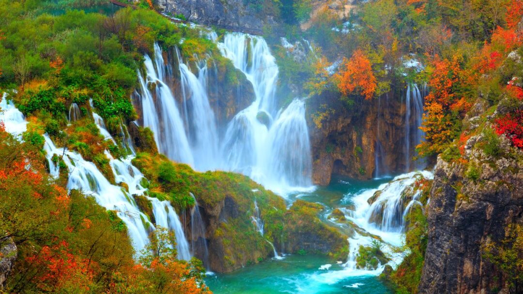 A breathtaking view of Plitvice Lakes National Park in Croatia. Crystal-clear turquoise waters flow between lush green vegetation and cascading waterfalls, creating a serene and picturesque landscape. Top 10 Spectacular Waterfalls to Visit.