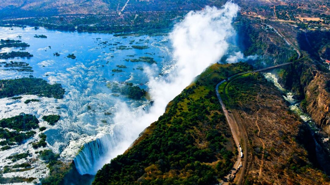 A breathtaking view of Victoria Falls, located between Zambia and Zimbabwe, showcasing the majestic waterfall and surrounding lush greenery. Top 10 Spectacular Waterfalls to Visit.